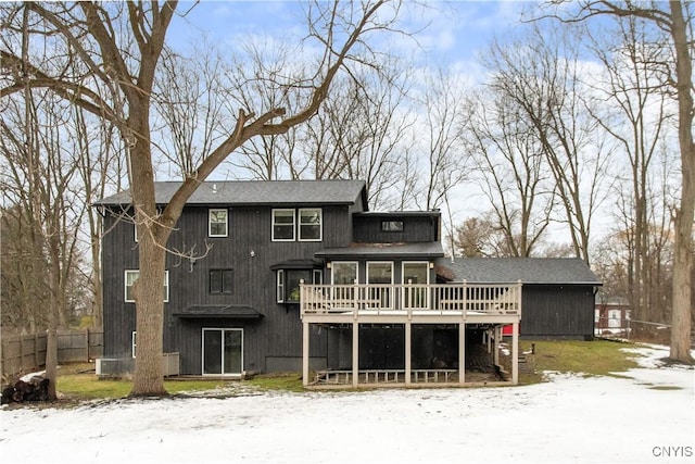 rear view of house with fence and a deck