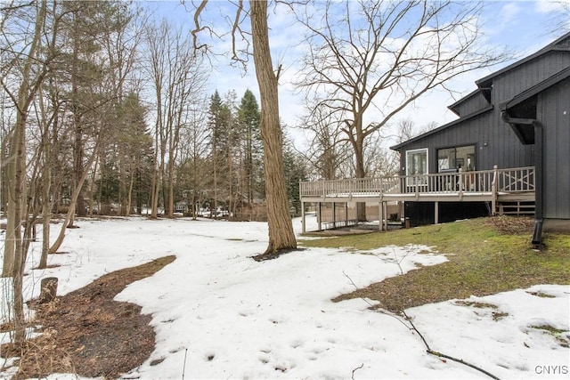 snowy yard featuring a wooden deck