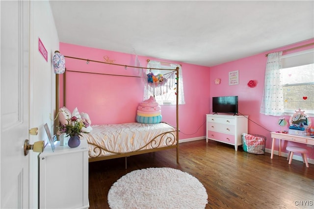 bedroom with baseboards and wood finished floors