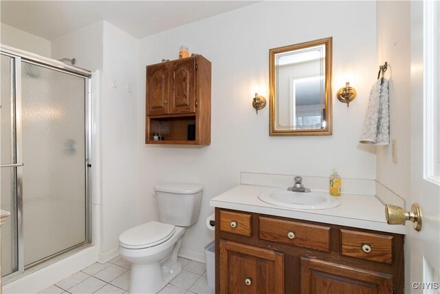 bathroom with toilet, vanity, baseboards, a shower stall, and tile patterned floors