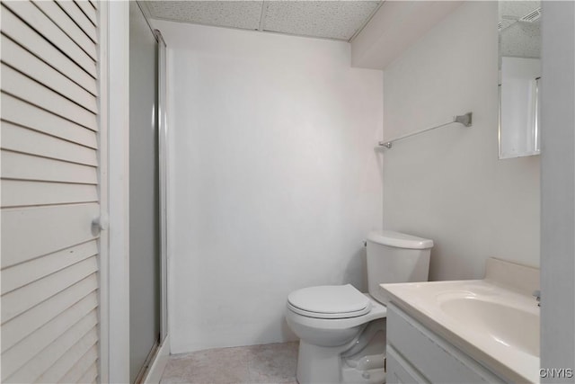 full bath featuring toilet, a stall shower, a drop ceiling, and vanity