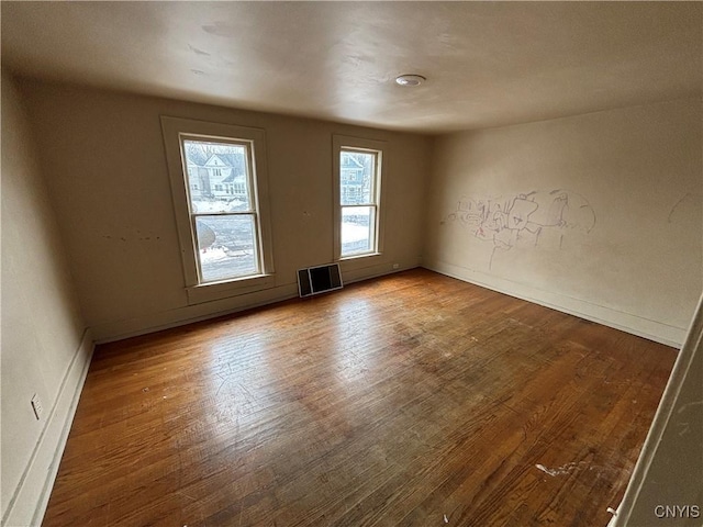 spare room with wood-type flooring and visible vents