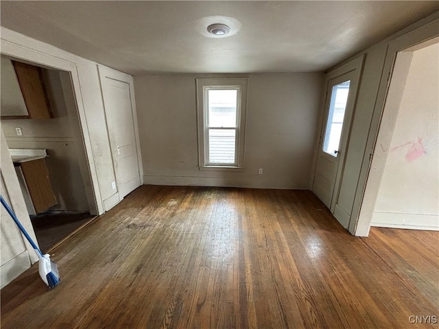 interior space with dark wood-type flooring and baseboards