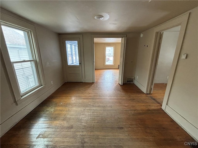 interior space featuring wood-type flooring, visible vents, and baseboards