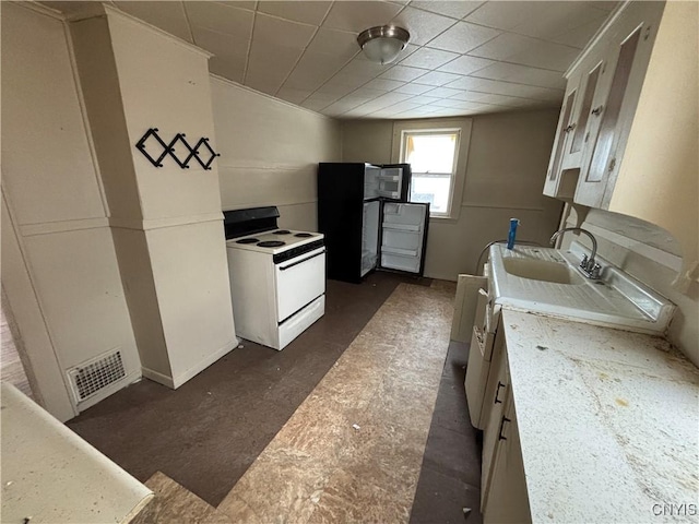 kitchen with visible vents, white range with electric cooktop, a drop ceiling, light countertops, and a sink