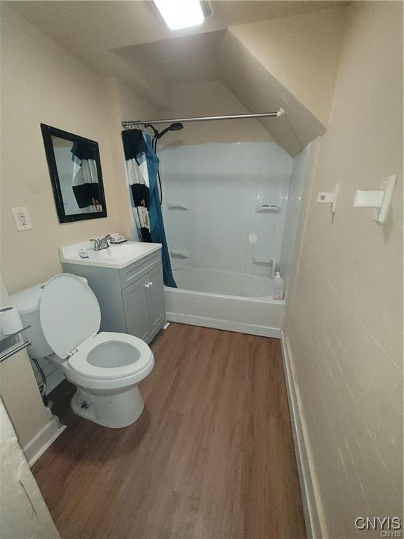 bathroom featuring shower / bath combination with curtain, vanity, toilet, and wood finished floors