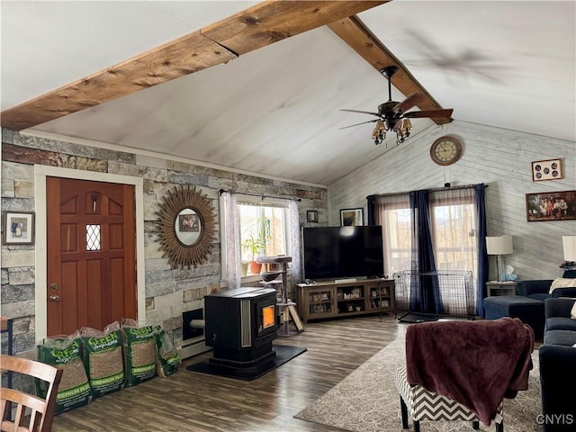 living room featuring ceiling fan, wood finished floors, a wood stove, vaulted ceiling with beams, and baseboard heating