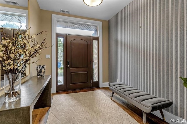 foyer featuring light wood-type flooring, visible vents, and baseboards