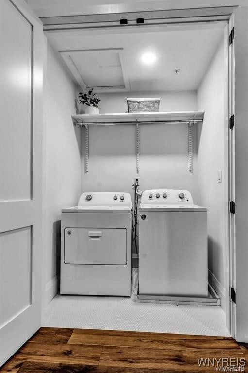 clothes washing area featuring laundry area, wood finished floors, and washer and dryer