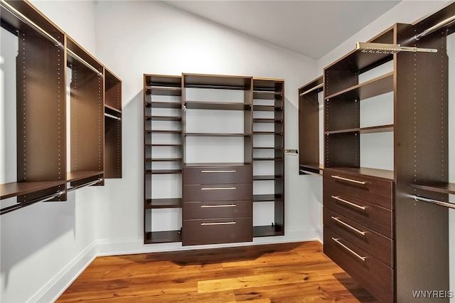 spacious closet with lofted ceiling and wood finished floors