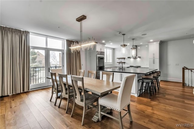 dining area featuring baseboards, french doors, wood finished floors, and recessed lighting