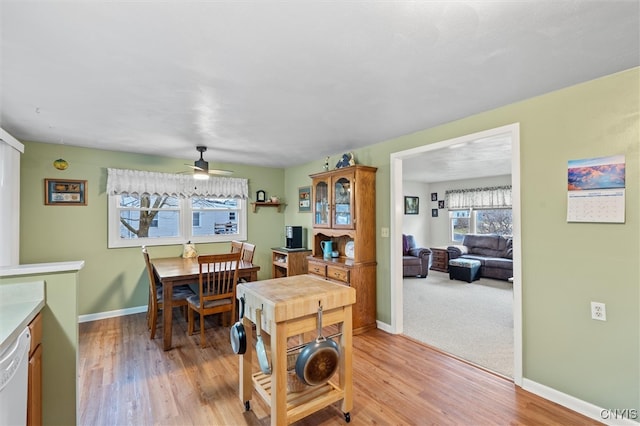 dining area featuring ceiling fan, light wood finished floors, and baseboards