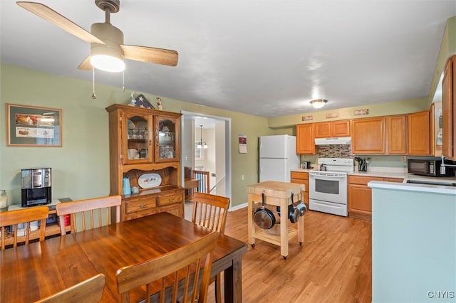 kitchen with white appliances, a ceiling fan, light wood-style floors, light countertops, and under cabinet range hood