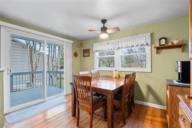 dining space with ceiling fan, light wood-type flooring, and baseboards