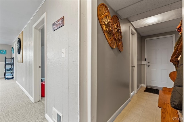 corridor with light carpet, baseboards, visible vents, and a drop ceiling