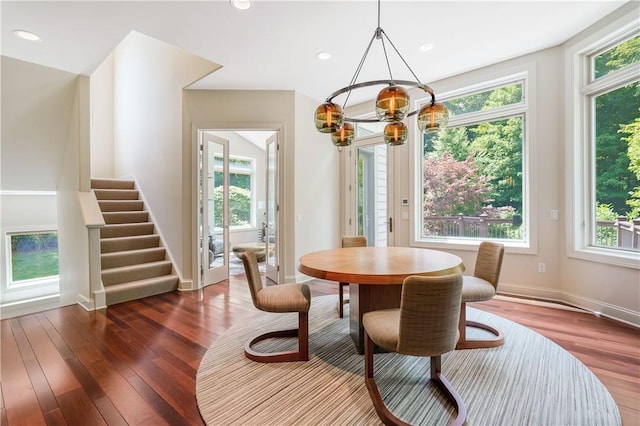 dining room featuring a wealth of natural light, stairs, and wood finished floors