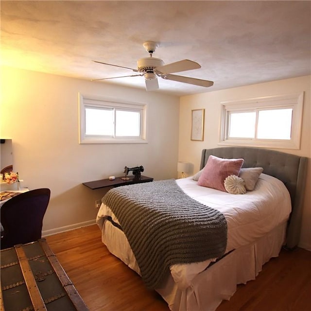 bedroom with wood finished floors, a ceiling fan, and baseboards