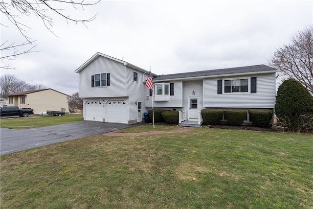 raised ranch featuring aphalt driveway, a front yard, and an attached garage