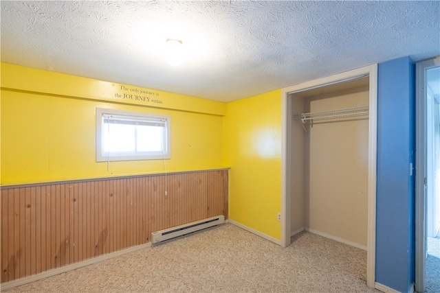 unfurnished bedroom featuring a baseboard radiator, carpet floors, a textured ceiling, and a closet