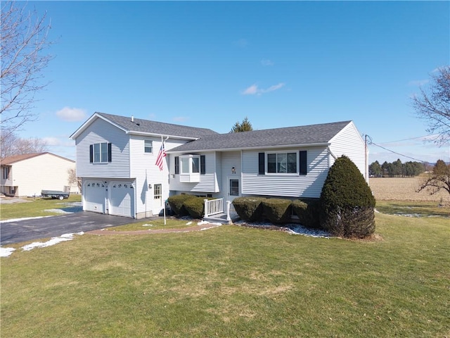 view of front of property with a garage, a front lawn, and driveway