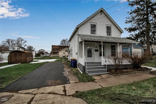 192 Cottage St, Lockport-City, NY 14094 - view of front of home with a shingled roof, a storage unit, an outdoor structure, a porch, and a front yard