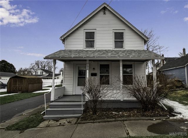 192 Cottage St, Lockport-City, NY 14094 - view of front facade featuring a porch, an outdoor structure, a shingled roof, and a shed