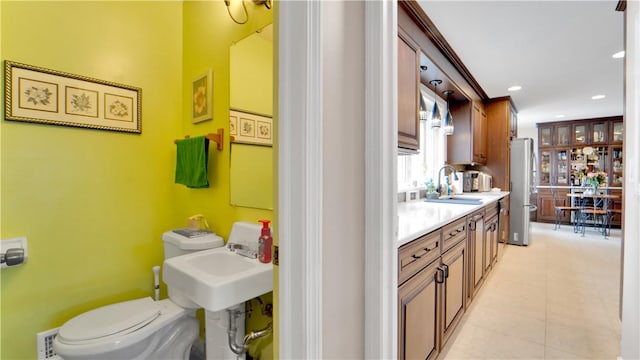 bathroom featuring recessed lighting, a sink, toilet, and tile patterned floors