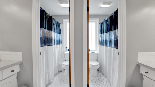 full bath with toilet, curtained shower, tile patterned floors, and vanity