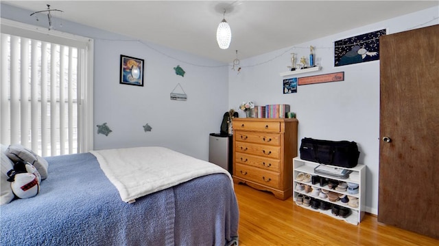 bedroom featuring vaulted ceiling and light wood-type flooring