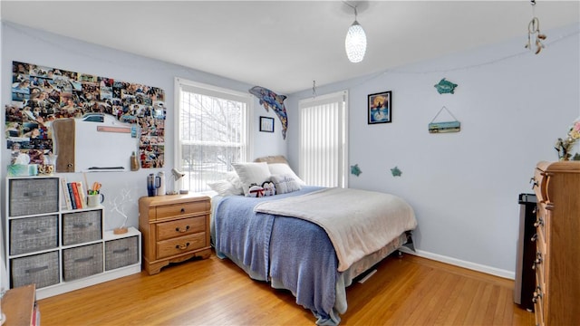 bedroom with light wood-type flooring and baseboards