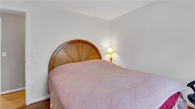 bedroom with baseboards and wood finished floors