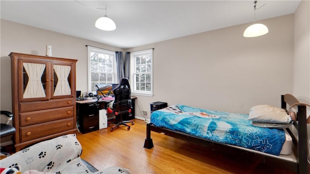 bedroom with light wood finished floors and baseboards