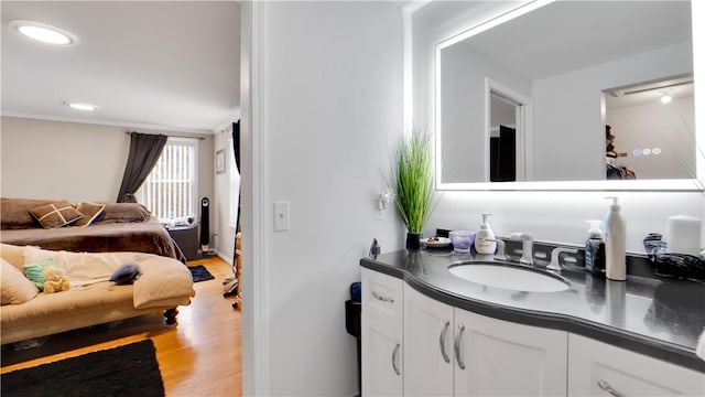 bathroom featuring wood finished floors, vanity, and recessed lighting