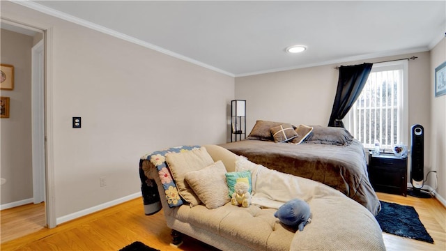 bedroom featuring light wood-style floors, baseboards, and ornamental molding