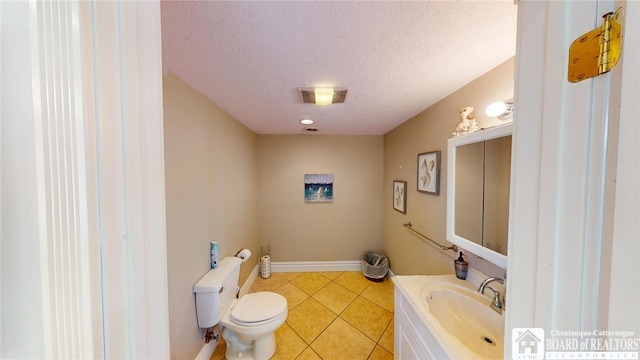 half bath with a textured ceiling, toilet, vanity, visible vents, and tile patterned floors