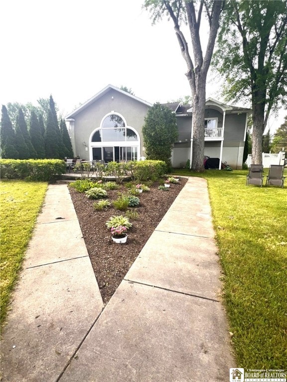 view of front facade with stucco siding and a front yard