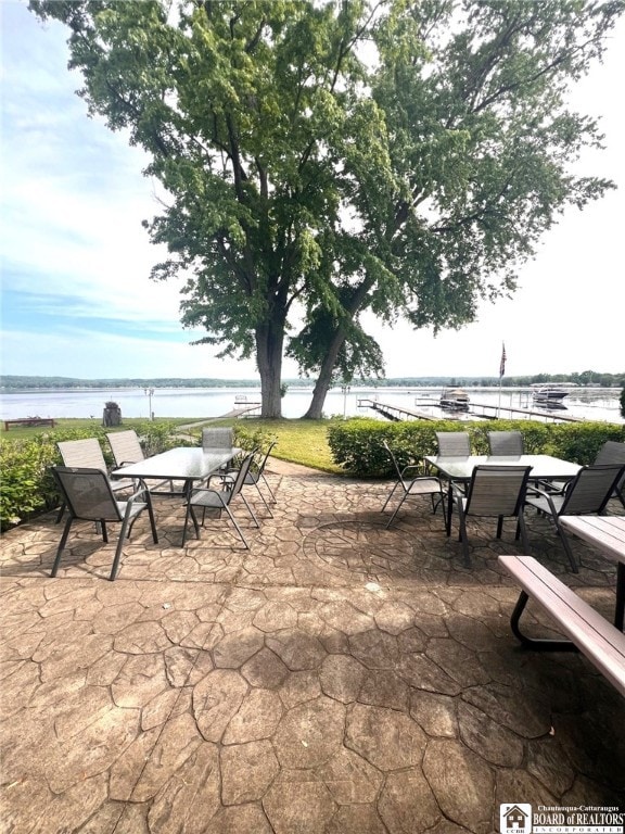 view of patio with outdoor dining area and a water view