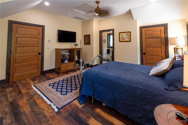 bedroom featuring ceiling fan, wood finished floors, baseboards, vaulted ceiling, and attic access