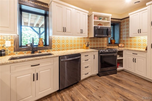 kitchen with open shelves, appliances with stainless steel finishes, white cabinets, a sink, and wood finished floors