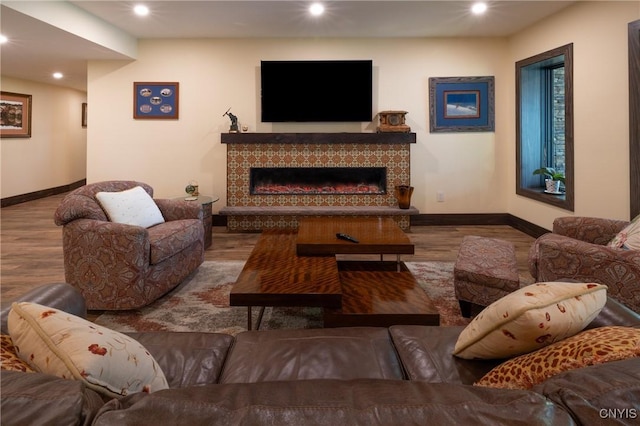 living room with recessed lighting, a fireplace, wood finished floors, and baseboards