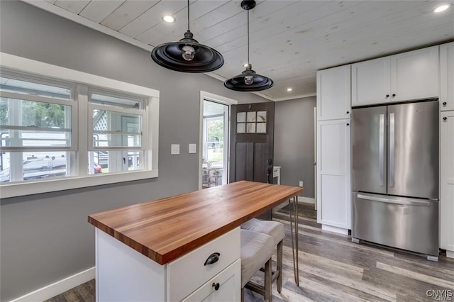 kitchen featuring butcher block counters, recessed lighting, freestanding refrigerator, and white cabinets