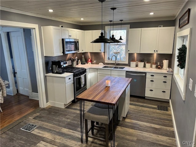 kitchen featuring stainless steel appliances, white cabinets, dark wood-type flooring, and a sink