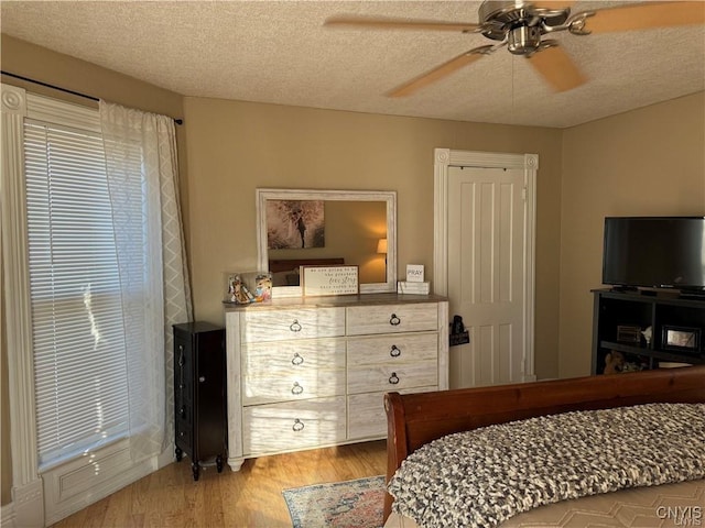 bedroom featuring a textured ceiling, wood finished floors, and a ceiling fan