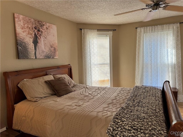 bedroom with ceiling fan and a textured ceiling