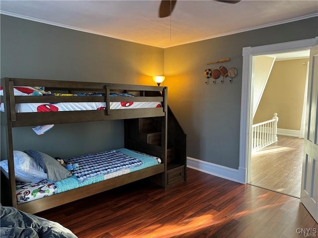 bedroom with crown molding, baseboards, and wood finished floors