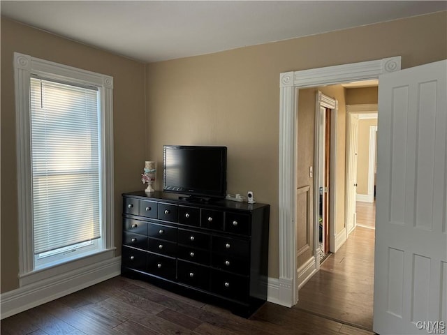 bedroom featuring baseboards and dark wood-type flooring