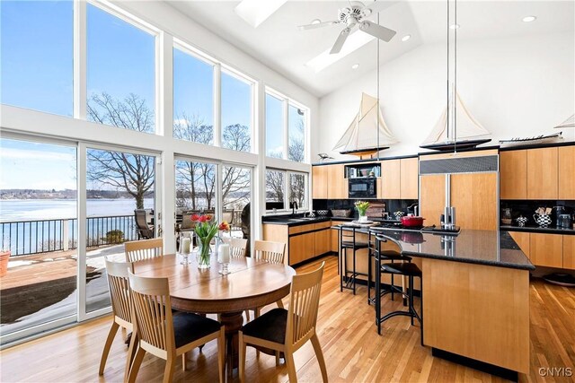 kitchen with a center island, plenty of natural light, light wood finished floors, and built in appliances