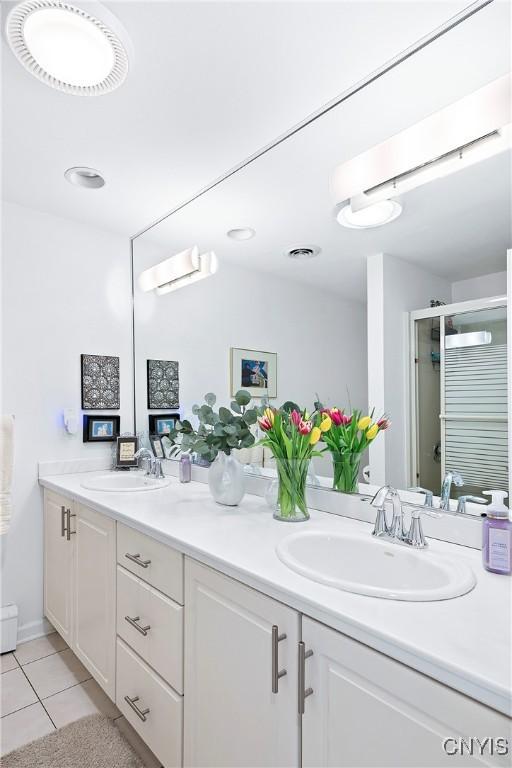 bathroom featuring double vanity, tile patterned flooring, a sink, and visible vents