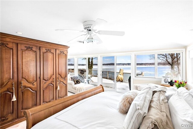 bedroom featuring a ceiling fan, access to outside, and a water view