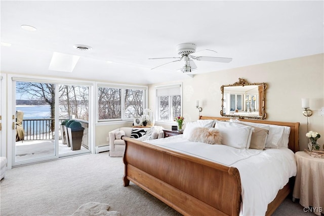 carpeted bedroom with access to exterior, multiple windows, visible vents, and a baseboard heating unit